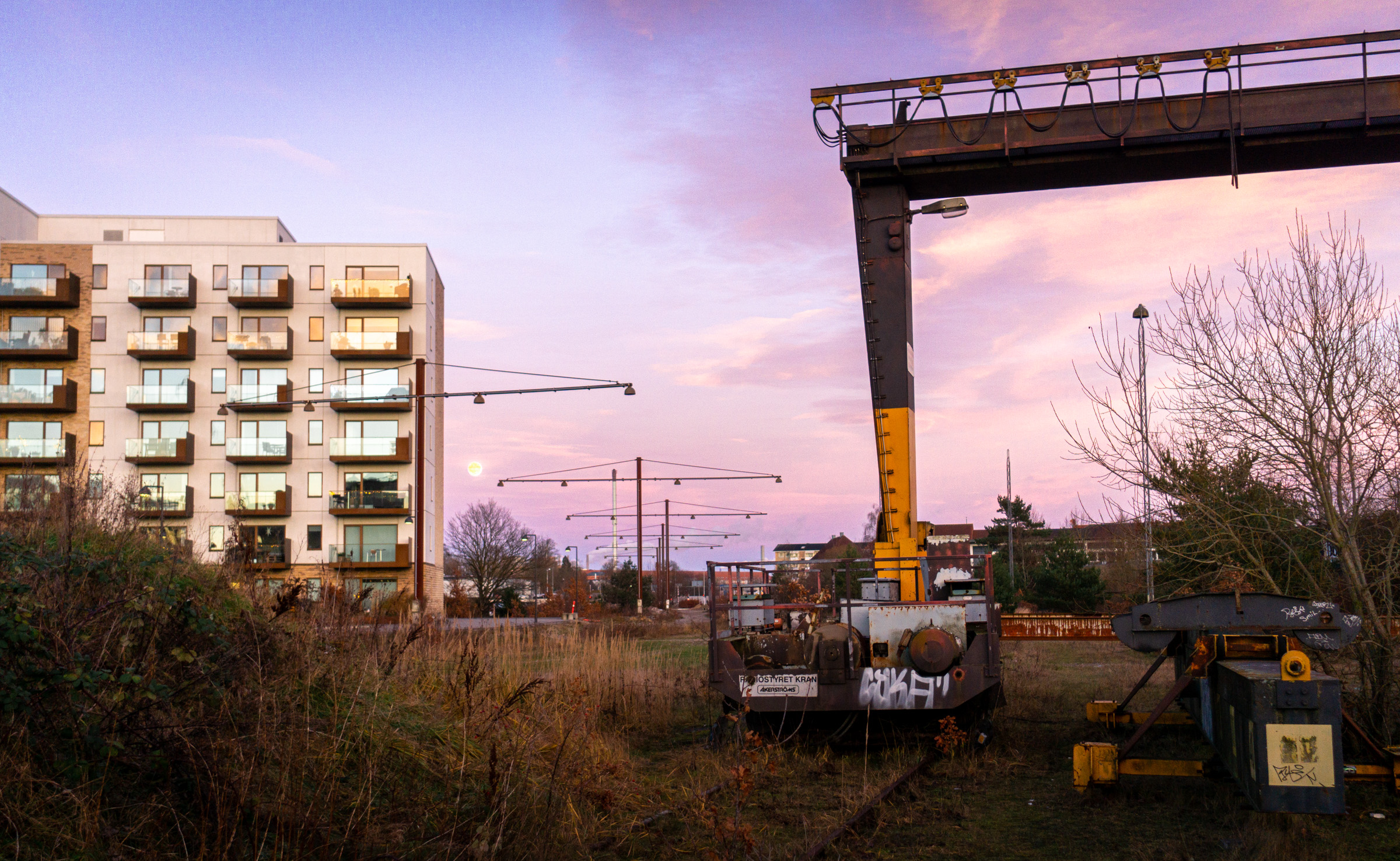 Sunset over an old rail yard, with a modern building on the left