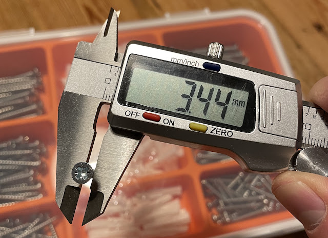 A screw diameter being measured with a caliper.
